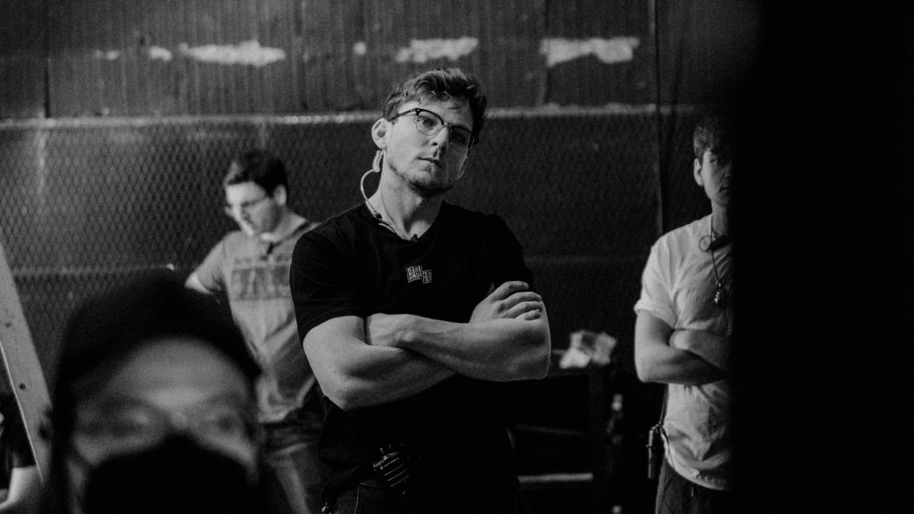 Director watching a take, arms folded