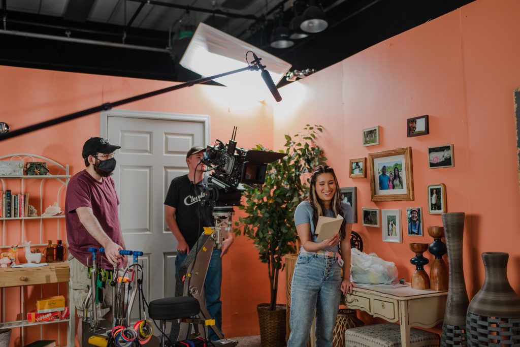 Studio set dressed as a room, with lighting rig and crew