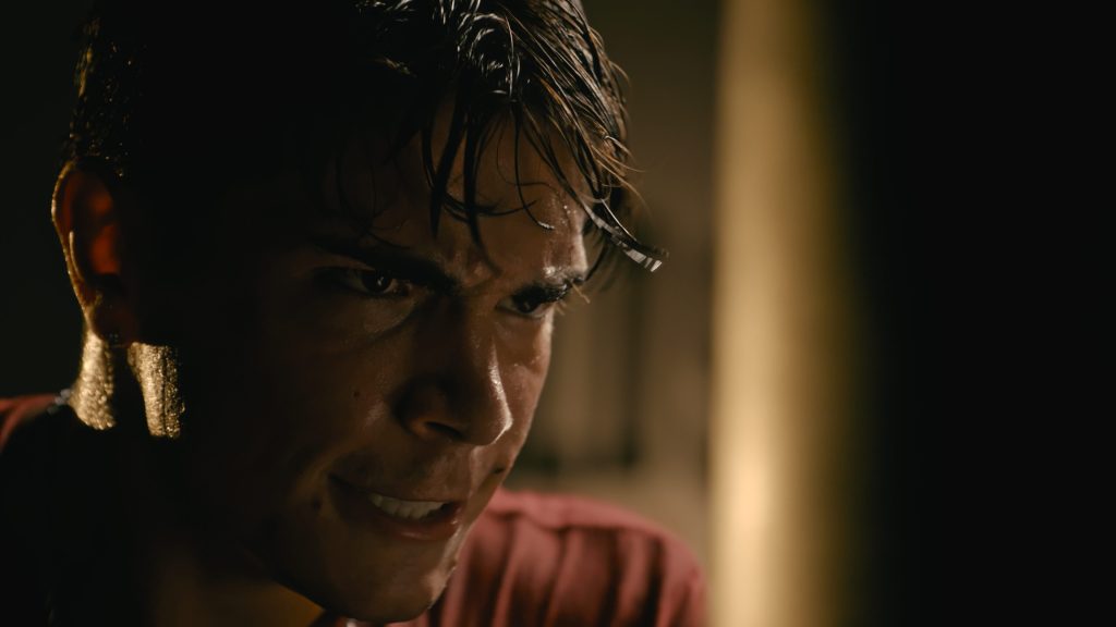 Close-up of a young man mid-shout in warm light