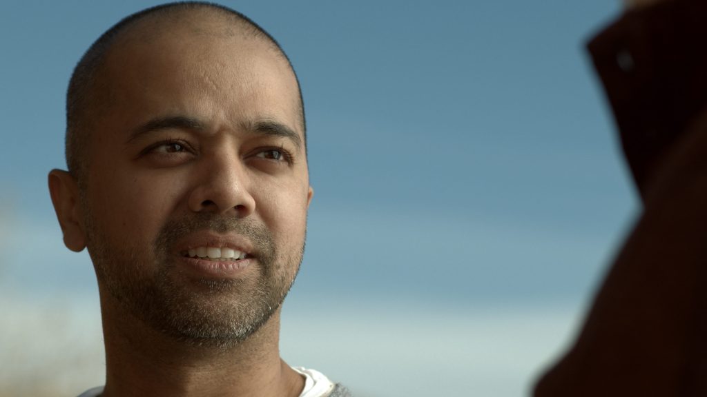 Close portrait of a man against a bright blue sky