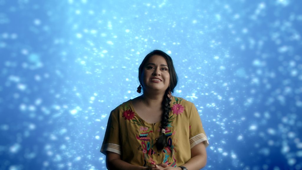 Singer performing against a deep blue, star-flecked backdrop